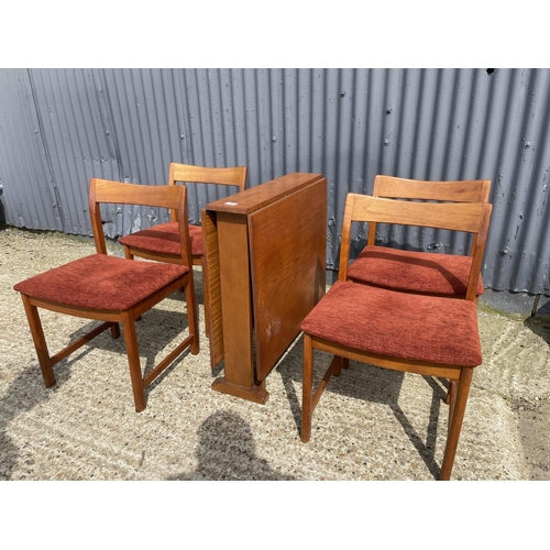 34 - A danish style teak drop leaf dining table together with four teak dining chairs