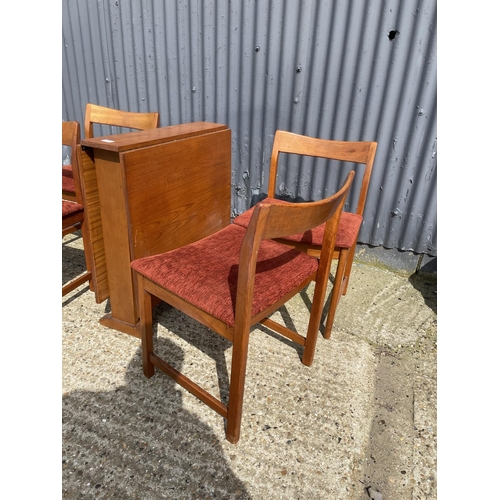 34 - A danish style teak drop leaf dining table together with four teak dining chairs