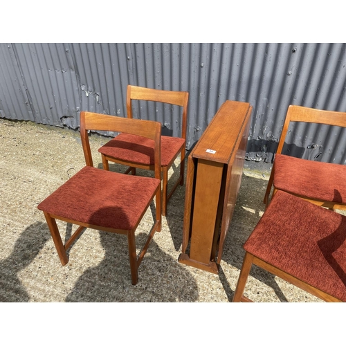 34 - A danish style teak drop leaf dining table together with four teak dining chairs