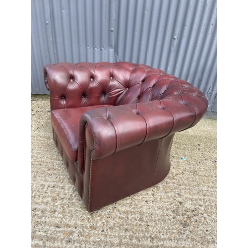 39 - An oxblood red leather chesterfield club armchair