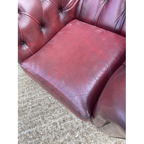 39 - An oxblood red leather chesterfield club armchair