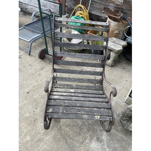 441 - A vintage ornate iron framed garden rocking seat with hardwood slatted seat