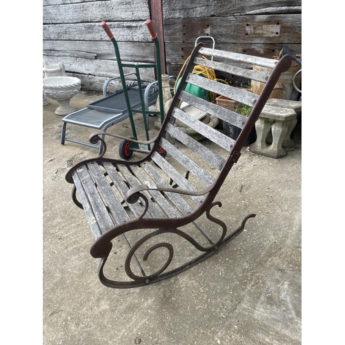 441 - A vintage ornate iron framed garden rocking seat with hardwood slatted seat