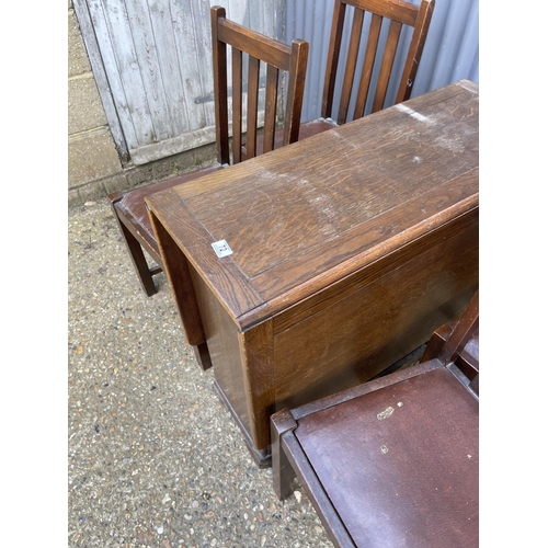 72 - A ealry 20th century oak drop leaf table together with four chairs