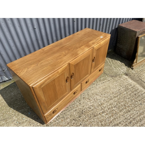 98 - A mid century ercol sideboard with three doors over two drawers 130x44x77