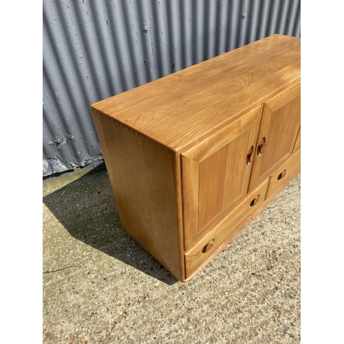 98 - A mid century ercol sideboard with three doors over two drawers 130x44x77