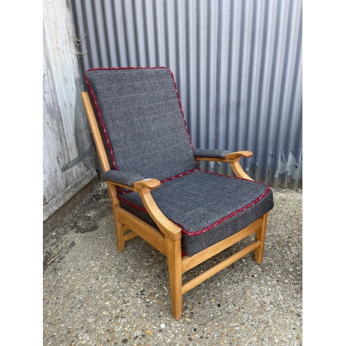 25 - A teak framed armchair with modern grey upholstery together with a modern stripe pattern armchair