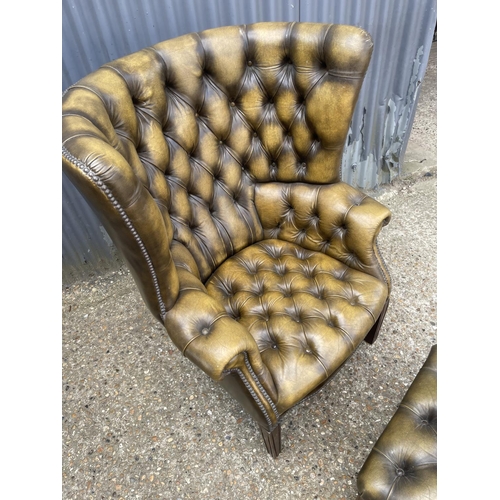 40 - A antique green leather chesterfield barrelled back armchair together with matching footstool