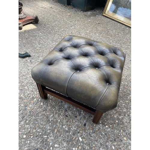 40 - A antique green leather chesterfield barrelled back armchair together with matching footstool