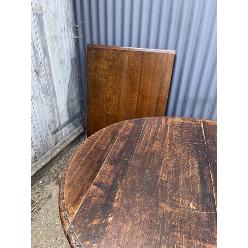 48 - A large oak oval dining table with pedestal base decorated with four carved  lions heads 127x110 plu... 