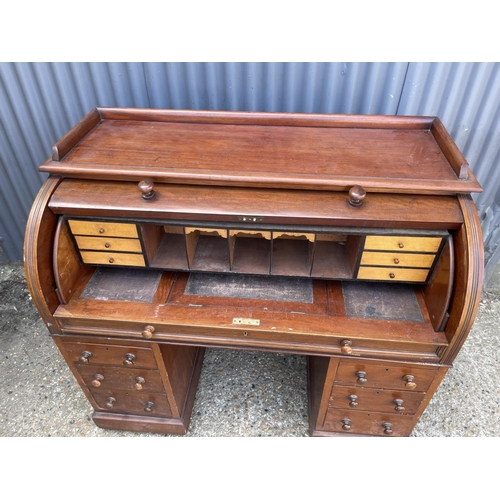 67 - A Victorian mahogany twin pedestal desk with cylinder top, revealing a satinwood fitted interior and... 