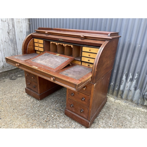 67 - A Victorian mahogany twin pedestal desk with cylinder top, revealing a satinwood fitted interior and... 