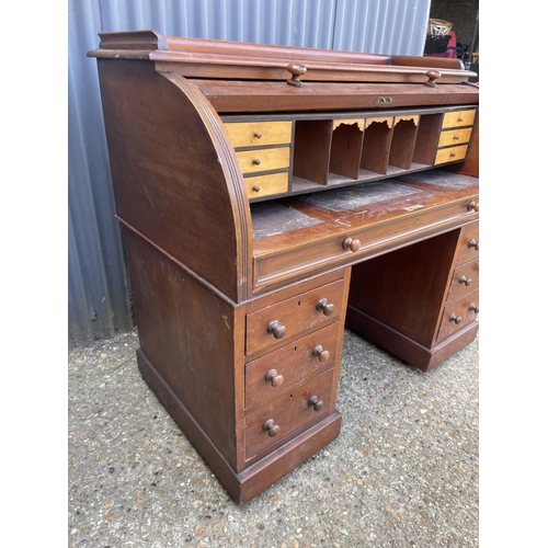 67 - A Victorian mahogany twin pedestal desk with cylinder top, revealing a satinwood fitted interior and... 