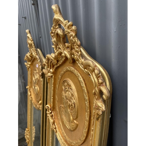 110 - A pair of large ornate gold gilt mirrors decorated with ladies facing each other 180x50 each