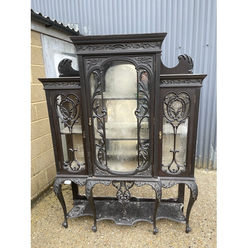 100A - An edwardian glazed display cabinet with creaping death carved decoration