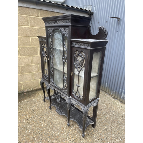 100A - An edwardian glazed display cabinet with creaping death carved decoration