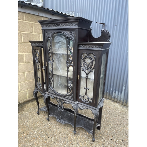 100A - An edwardian glazed display cabinet with creaping death carved decoration