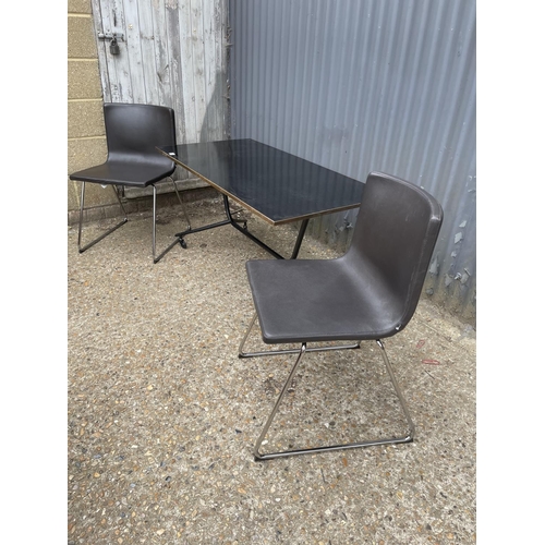 141 - A modern black trolley table together with two black leather and chrome chairs