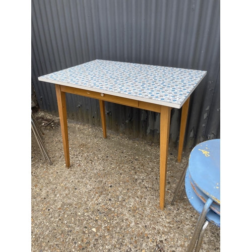 166 - A blue pattern formica kitchen table together with six blue bent ply stacking chairs