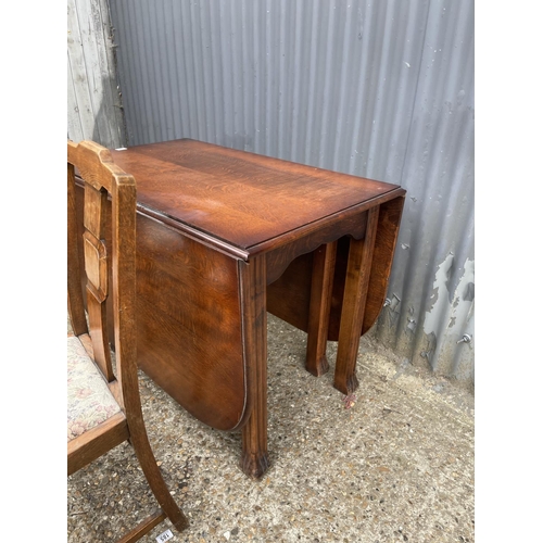 188 - An oak gate leg table and two chairs