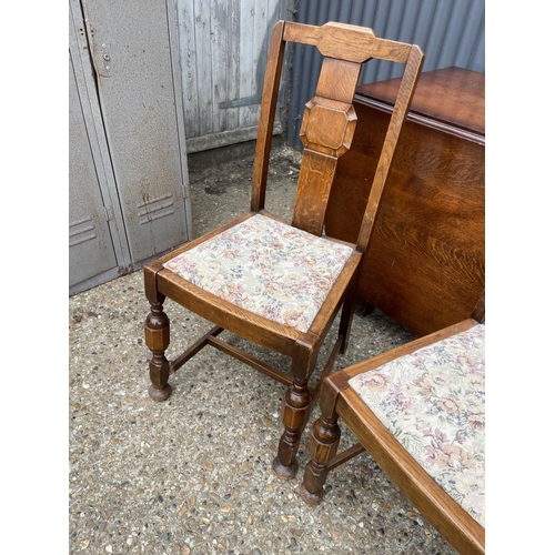 188 - An oak gate leg table and two chairs