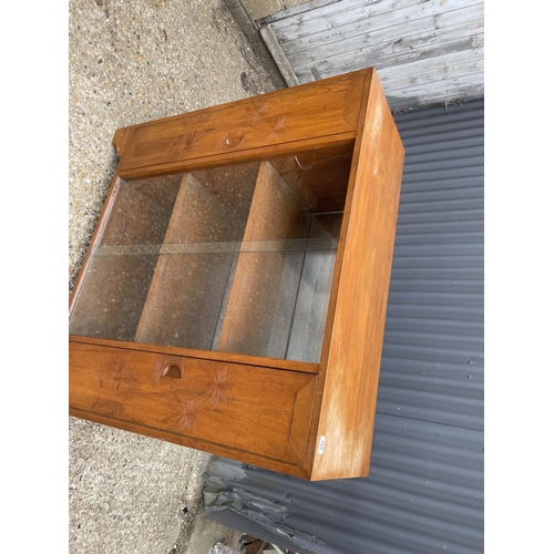 195 - An oriental hardwood cabinet with glazed central section and two carved doors  118x42x118