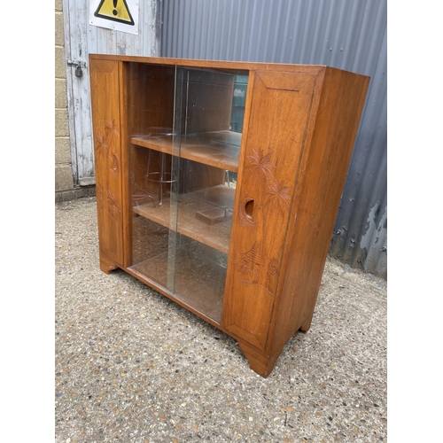 195 - An oriental hardwood cabinet with glazed central section and two carved doors  118x42x118