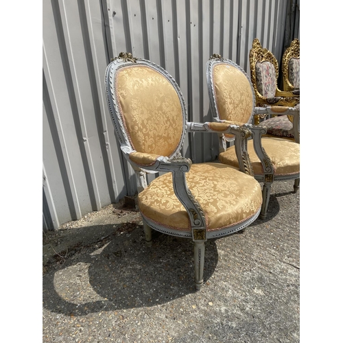 22 - A pair of grey painted and peach upholstered continental elbow chairs