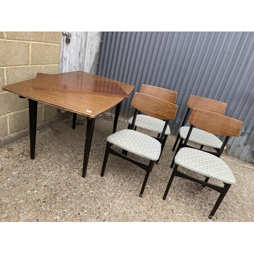 34 - A retro teak extending dining table with four chairs