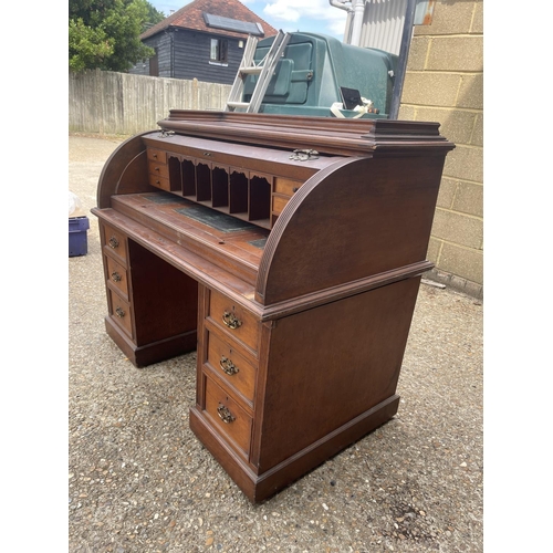 70 - An Edwardian cylinder top desk with dickens style writing surface and fitted interior and drawers