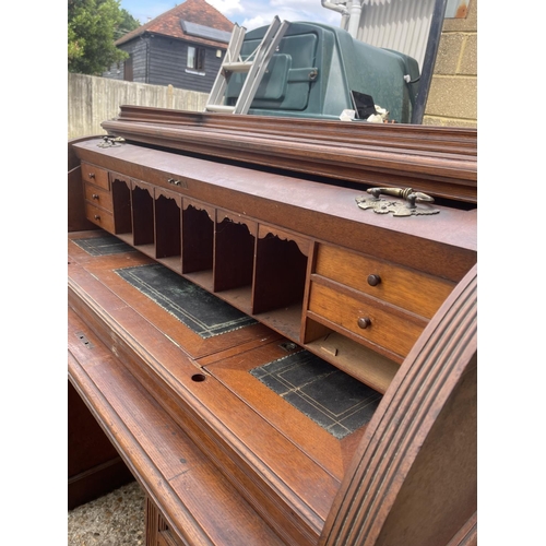 70 - An Edwardian cylinder top desk with dickens style writing surface and fitted interior and drawers