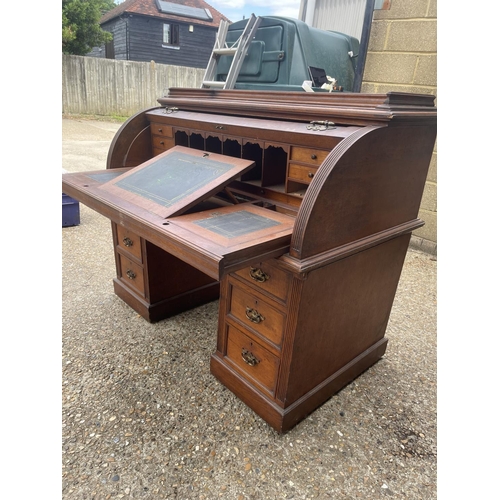 70 - An Edwardian cylinder top desk with dickens style writing surface and fitted interior and drawers