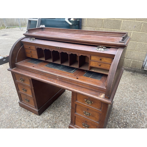 70 - An Edwardian cylinder top desk with dickens style writing surface and fitted interior and drawers