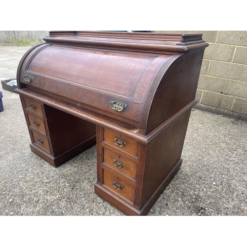 70 - An Edwardian cylinder top desk with dickens style writing surface and fitted interior and drawers