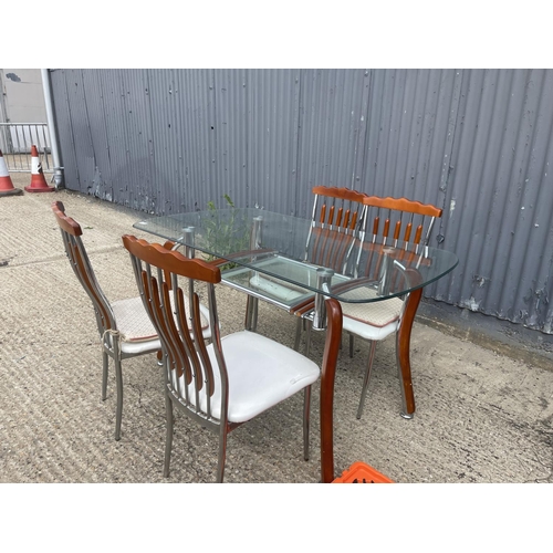 71 - An Italian glass and chrome dining table together with four chairs