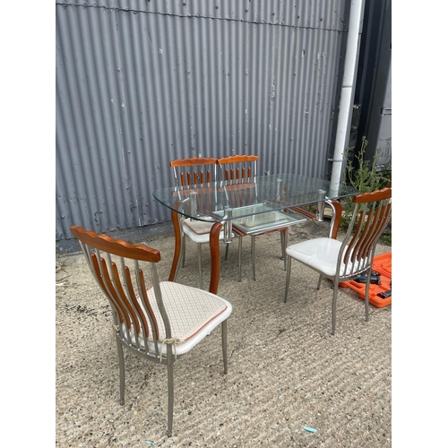 71 - An Italian glass and chrome dining table together with four chairs