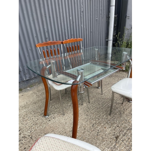 71 - An Italian glass and chrome dining table together with four chairs