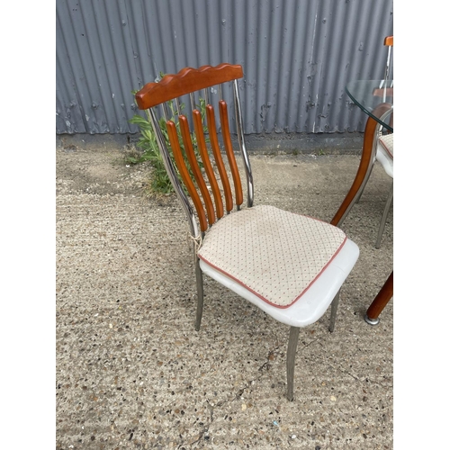 71 - An Italian glass and chrome dining table together with four chairs