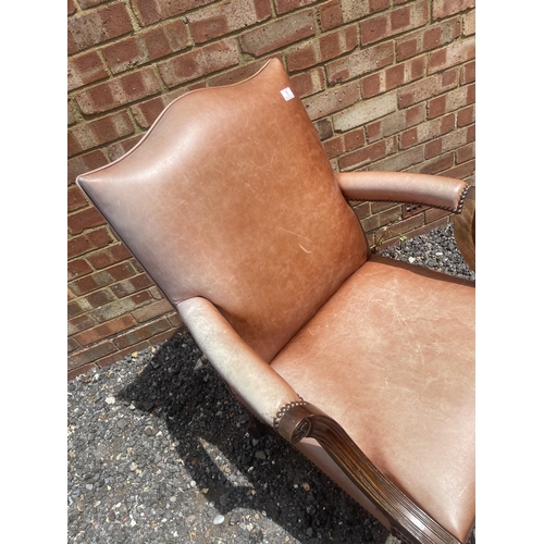 1 - A mahogany framed brown leather upholstered desk chair on ball and claw feet