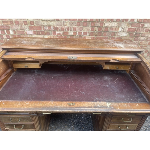 11 - A large good quality American walnut patent roll top desk with fitted interior and 9 locking drawers... 