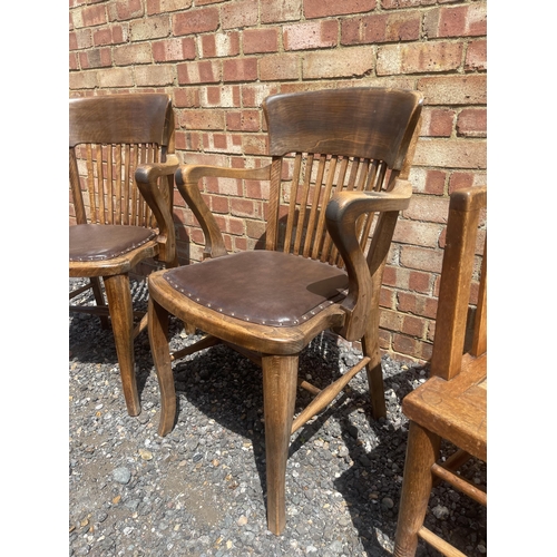 12 - A pair of American style oak office chairs together with another rush seat oak elbow chair