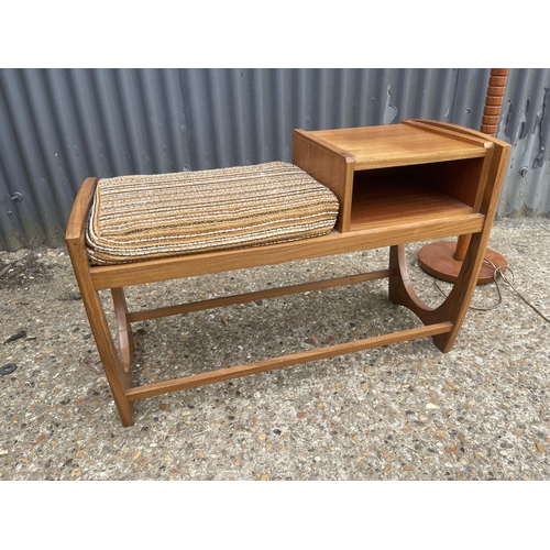 132 - A teak telephone seat together with a teak standard lamp