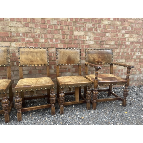 14 - A set of six oak framed dining chairs with tan brown seats and brass studs