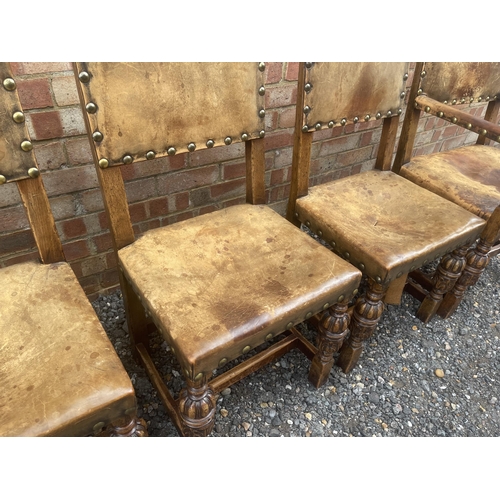 14 - A set of six oak framed dining chairs with tan brown seats and brass studs