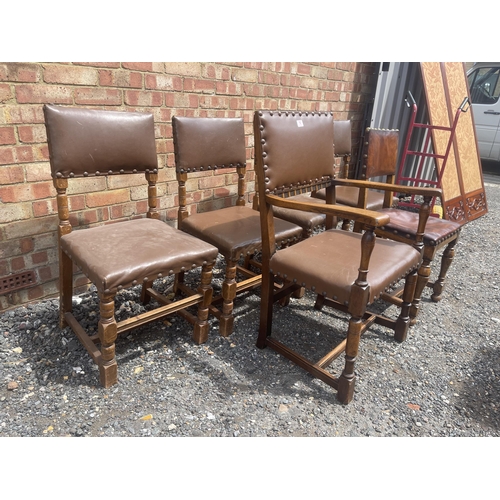 16 - A set of six oak and brown leather dining chairs including one carver and all with brass stud decora... 