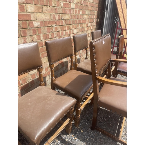 16 - A set of six oak and brown leather dining chairs including one carver and all with brass stud decora... 