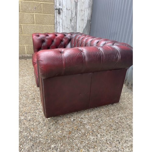 165 - A red leather chesterfield two seater sofa 160cm wide