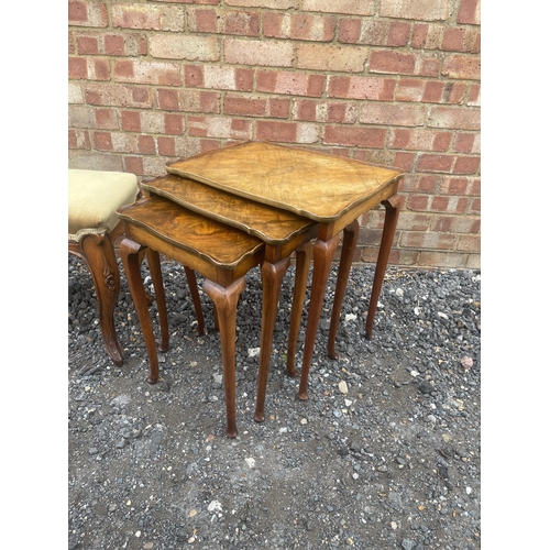 17 - A Victorian gold upholstered walnut framed window seat/duet stool together with a walnut nest of thr... 