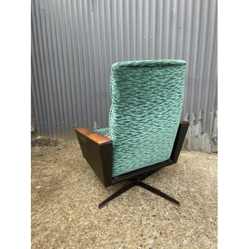 179 - A mid century retro swivel and recliner chair upholstered green