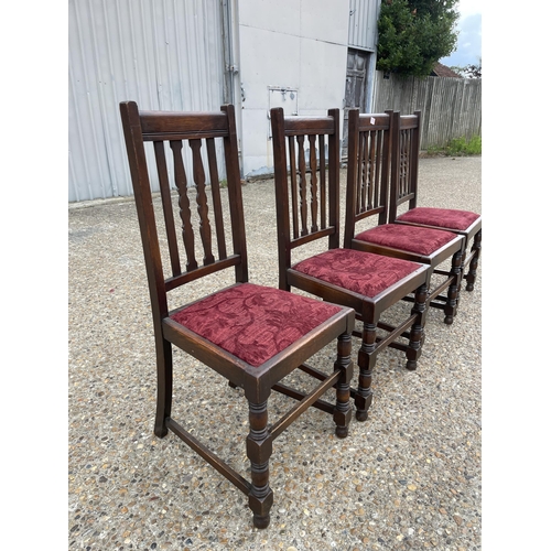 198 - A set of four early 20th century oak dining chairs with red upholstered drop in seats